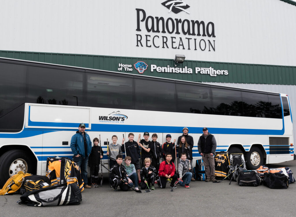 Sports group outside a Wilson's Transport chartered bus